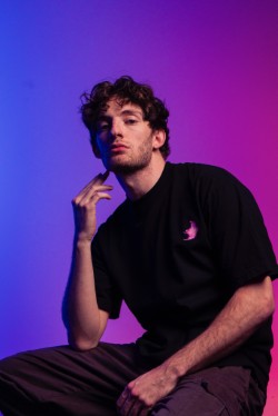 Studio portrait photographed by Malik Payton with purple and blue lighting.